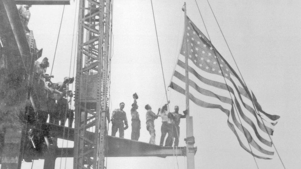 Construction workers celebrate the completion of the iron work on the Empire State Building, Manhattan, circa 1930.