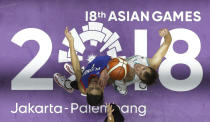 In this Aug. 16, 2018, file photo, Philippines' John Erram, left, and Kazakhstan's Dmitriy Gavrilov jump for ball possession during their men's basketball match at the 18th Asian Games in Jakarta, Indonesia on Thursday, Aug. 16, 2018. (AP Photo/Aaron Favila, File)