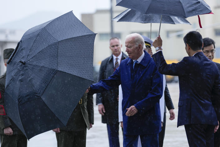 President Joe Biden, center, holds an umbrella after disembarking from Air Force One at Marine Corps Air Station Iwakuni in Iwakuni, Japan, Thursday, May 18, 2023. Biden is traveling to attend the G-7 Summit in Hiroshima, Japan. (AP Photo/Susan Walsh)