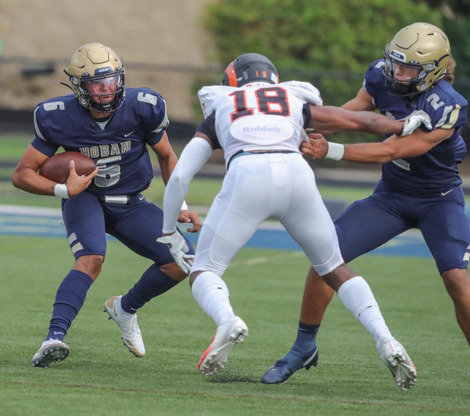 Hoban quarterback JacQai Long, left, gets a block from Jayvian Crable during the first quarter against Erie Cathedral Prep on Friday, Aug. 26, 2022 in Akron, Ohio, at Dowed Field.
(Photo: PHIL MASTURZO, AKRON BEACON JOURNAL)