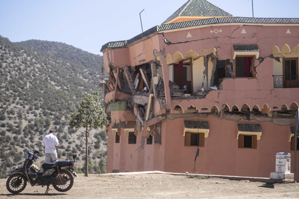 CORRECTS NAME OF THE VILLAGE - A man stands next to a damaged hotel after the earthquake in Moulay Brahim village, near the epicentre of the earthquake, outside Marrakech, Morocco, Saturday, Sept. 9, 2023. A rare, powerful earthquake struck Morocco late Friday night, killing more than 800 people and damaging buildings from villages in the Atlas Mountains to the historic city of Marrakech. But the full toll was not known as rescuers struggled to get through boulder-strewn roads to the remote mountain villages hit hardest. (AP Photo/Mosa'ab Elshamy)