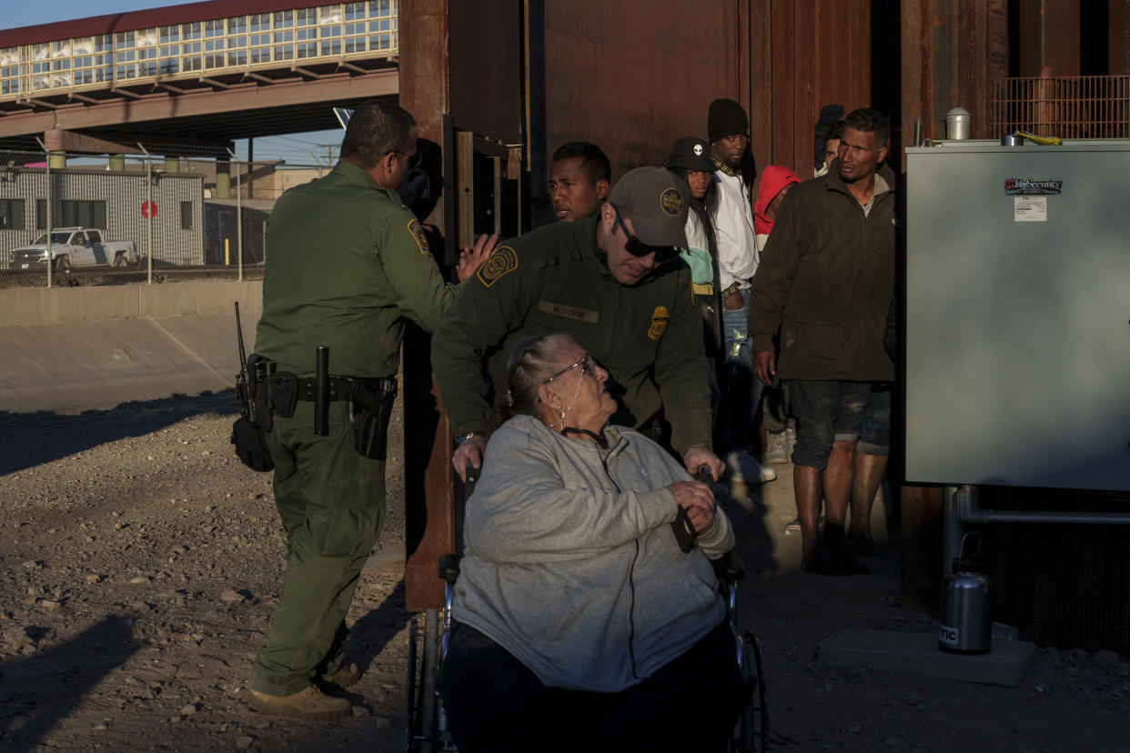 Después de cruzar el Río Bravo hacia El Paso, Texas, agentes de la Patrulla Fronteriza de Estados Unidos trasladan en su silla de ruedas a María del Carmen Verastigui, una migrante peruana que viajó sola a la frontera entre Estados Unidos y México, el 21 de diciembre de 2022. (Paul Ratje/The New York Times)
