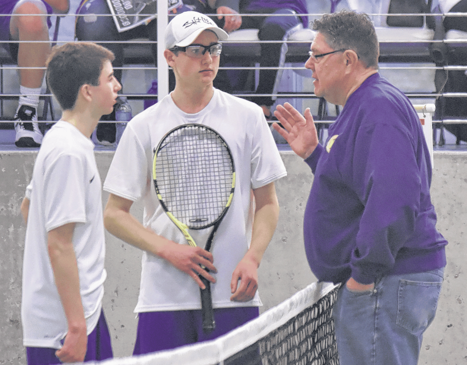 Head coach of the Watertown High School boys tennis team Scott Ewald (right) talks strategy with his No. 3 doubles pairing Adam Kays (left) and Shawn Horning during the 2018 spring season. It was Ewald's final season as the team's head coach.