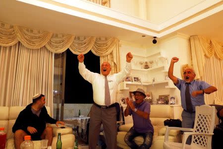 Israelis of Iranian origin cheer for an Iranian goal that was later ruled offside, as they watch the Iran-Spain World Cup match in the living room of the Hasid family in Jerusalem, June 20, 2018. Picture taken June 20, 2018. REUTERS/Ronen Zvulun