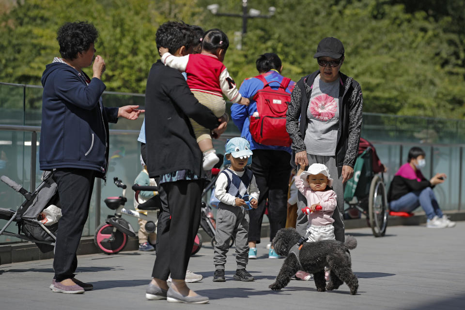 Residents bring their children to play on a compound near a commercial office building in Beijing on Monday, May 10, 2021. China’s population growth is falling closer to zero as fewer couples have children, the government announced Tuesday, adding to strains on an aging society with a shrinking workforce. (AP Photo/Andy Wong)