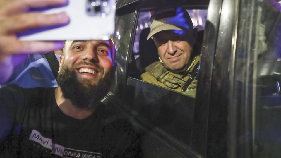 Yevgeny Prigozhin, the owner of the Wagner Group military company, right, sits inside a military vehicle posing for a selfie photo with a local civilian on a street in Rostov-on-Don, Russia, Saturday, June 24, 2023, prior to leaving an area of the headquarters of the Southern Military District. (AP Photo)