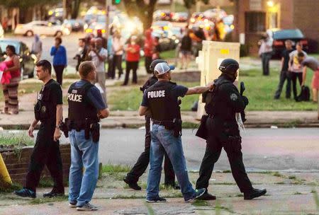 Police monitor the crowd as protesters gathered after a shooting incident in St. Louis, Missouri August 19, 2015. REUTERS/Kenny Bahr