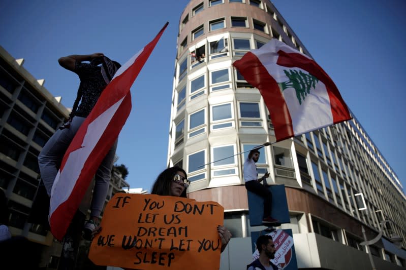 Protesters wave flags at a demonstration organised by students during ongoing anti-government protests in Beirut