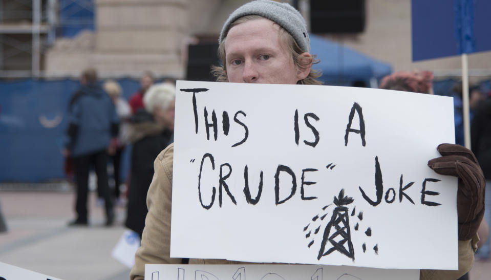 <p>Conner McElveen, an Oklahoma City teacher, holds a protest sign about the lack of taxation on the oil industry during a rally at the state Capitol on April 2, 2018, in Oklahoma City. (Photo: J Pat Carter/Getty Images) </p>