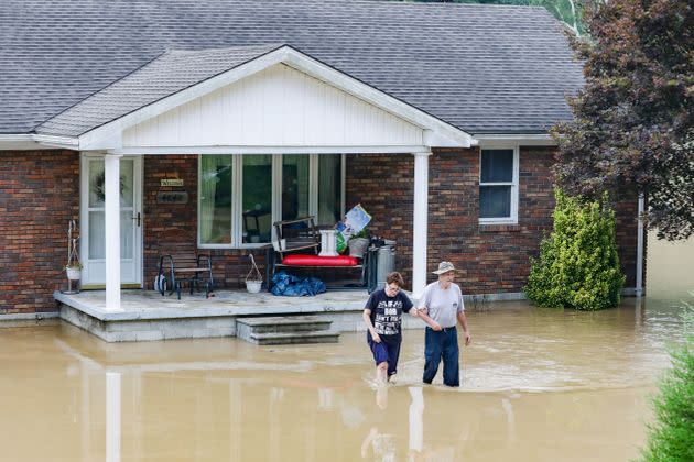 A couple abandons their home flooded by the waters of the North Fork of the Kentucky River in Jackson, Kentucky, on July 28. (Photo: LEANDRO LOZADA/AFP/Getty Images)