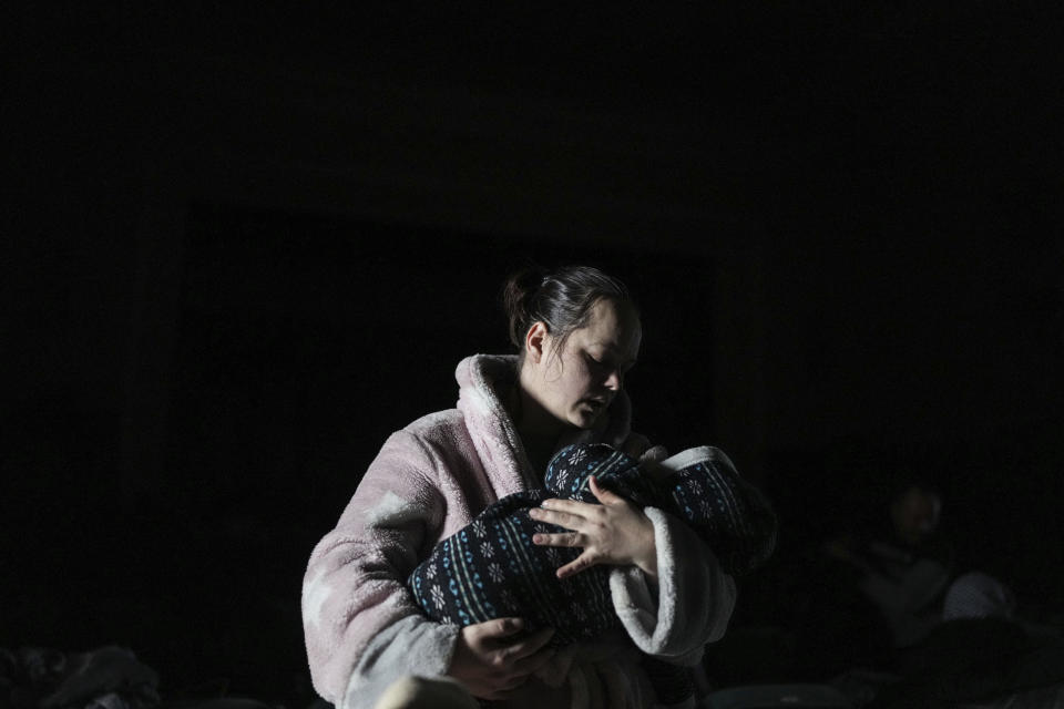 A woman holds a baby in a bomb shelter in in Mariupol, Ukraine, Tuesday, March 8, 2022. (AP Photo/Evgeniy Maloletka)