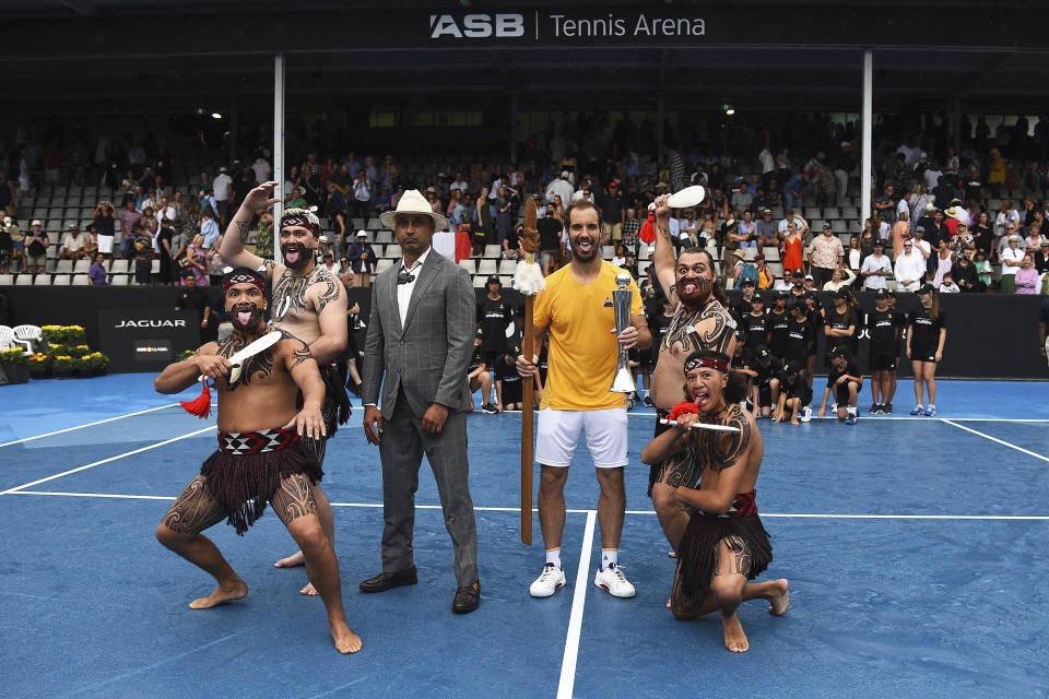 Richard Gasquet, center, of France poses with the trophy with local Maori perfomers after winning the men's singles final over Cameron Norrie of Britain at the ASB Classic tennis event in Auckland, New Zealand, Saturday, Jan. 14, 2023. (Andrew Cornaga/Photoport via AP)