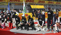 Drivers stand and knee against racism in the pit lane prior the Styrian Formula One Grand Prix race at the Red Bull Ring racetrack in Spielberg, Austria, Sunday, July 12, 2020. (Mark Thompson/Pool via AP)