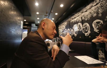 Shiro Fukai, 48, drinks distilled spirit at the Otasuke "izakaya" style pub and restaurant in Tokyo May 8, 2014. REUTERS/Toru Hanai