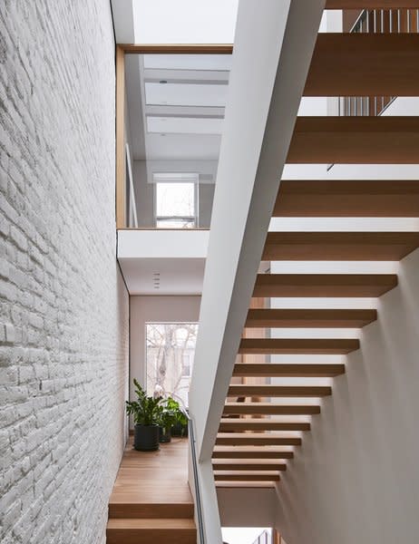 "There aren’t many row houses that treat vertical circulation and the relationship between public and private spaces the same way as [this house]," Shane says. White oak treads and a painted steel handrail make up the home's signature staircase. 

