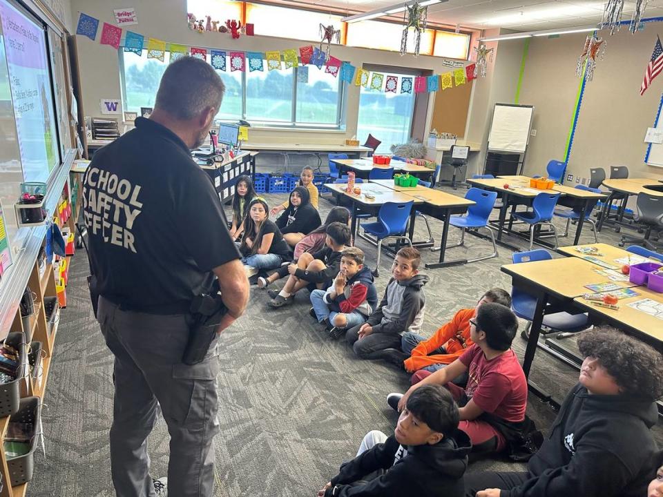 Former Kennewick Police Commander Scott Child talks with students at Amistad Elementary on the first day of school.