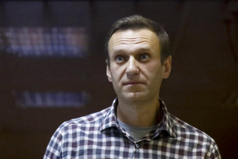 FILE - Russian opposition leader Alexei Navalny stands in a cage in the Babuskinsky District Court in Moscow, Russia on Saturday, Feb. 20, 2021. Russian authorities have levied new criminal charges against imprisoned opposition leader Alexei Navalny. Russian authorities have added imprisoned opposition leader Alexei Navalny and some of his top allies to the registry of terrorists and extremists, the latest move in a multi-pronged crackdown on opposition supporters, independent media and human rights activists. (AP Photo/Alexander Zemlianichenko, File)
