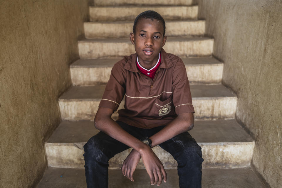 Mouhamed Sall, who is deaf, sits on the steps of the Guinaw Rail Sud public high school in Pikine, Senegal, Monday, March 18, 2024. Sall and three other students are part of a new approach in a small number of schools in Senegal that seat those who are deaf and hard of hearing with the rest of the class. (AP Photo/Sylvain Cherkaoui)