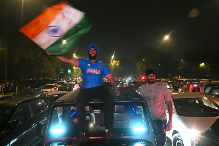 Cricket-crazy India erupted with midnight celebrations as fans in blue Indian shirts on cars and bikes took to the streets across big cities including the capital New Delhi (Arun SANKAR)