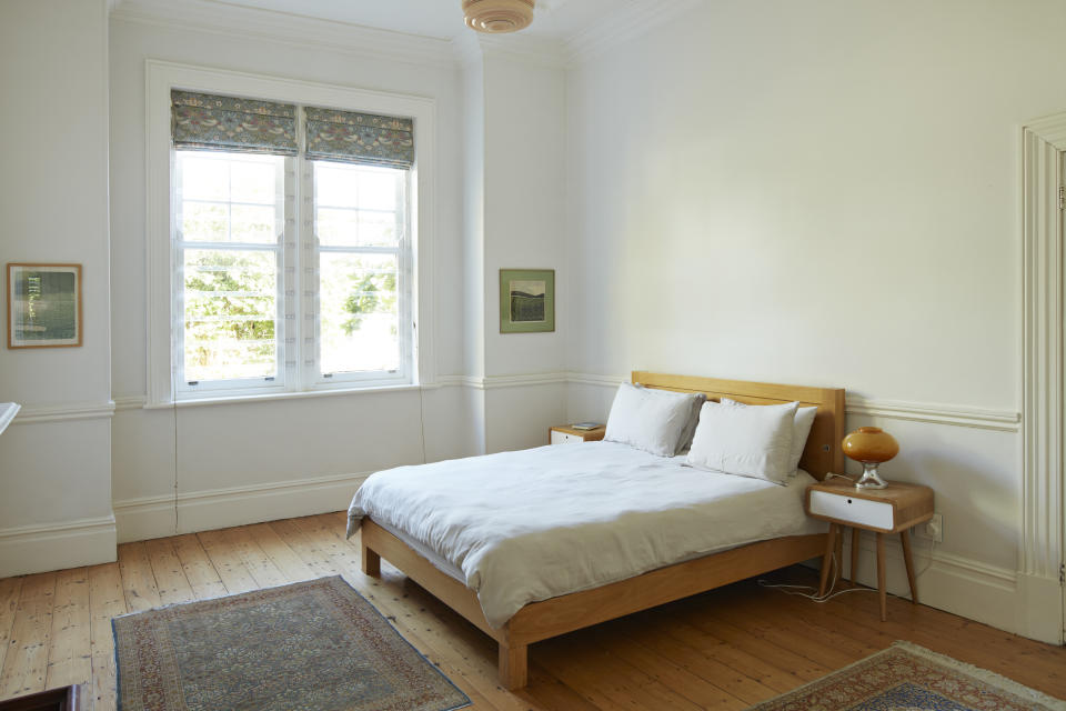 Wooden bed by window in bedroom at home