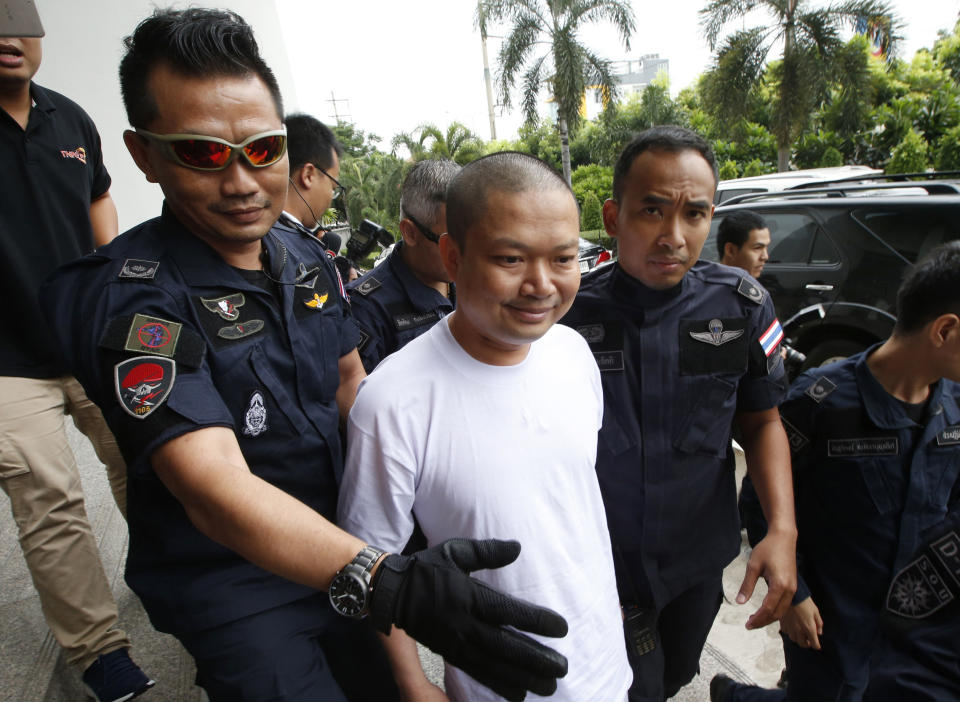 Ex-monk Wirapol Sukphol is escorted by the Department of Special Investigation officials to the prosecutor’s office in Bangkok last July. (PA)