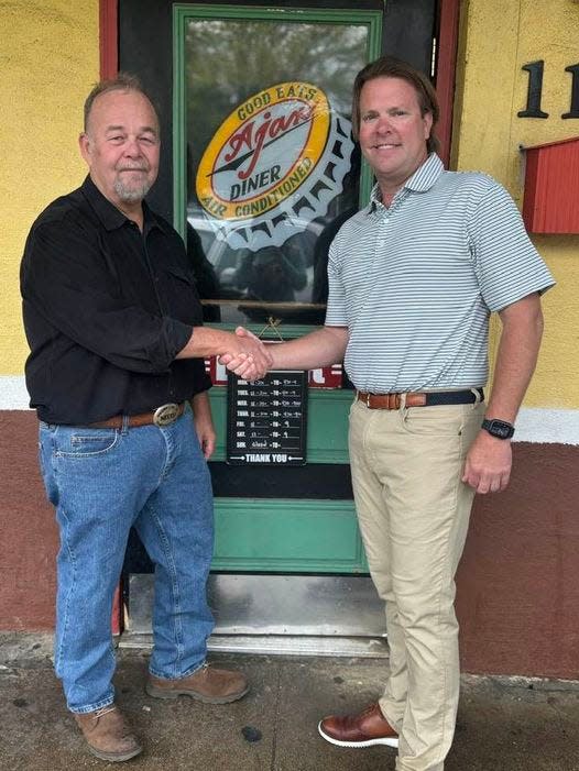 Randy Yates, left, shakes hands with Clay Scruggs. Yates sold the iconic Oxford restaurant Ajax Diner to Scruggs after 27 years in the business.