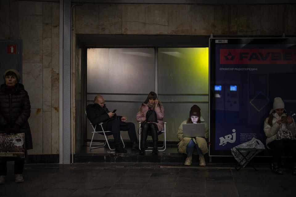 Gente sentada en una estación de metro utilizada como refugio antibombas mientras suena la alarma antiaérea en Kiev, Ucrania, el martes 14 de febrero de 2023. (AP Foto/Emilio Morenatti)