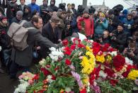 People gather on February 28, 2015 at the spot where Russian opposition leader Boris Nemtsov was shot dead, near Saint-Basil's Cathedral, in the center of Moscow