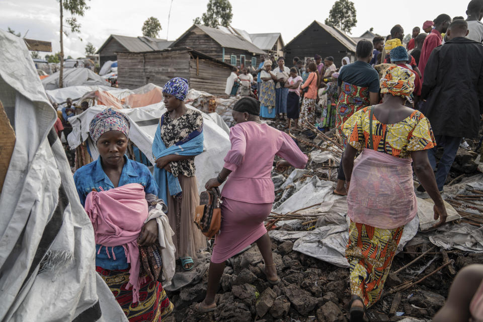 People gather at the side of an explosion in a refugee camp on the outskirts of Goma, Democratic Republic of the Congo, Friday, May, 3, 2024. The Congolese army says a bomb at a refugee camp in eastern Congo has killed at least 5 people, including children. An army spokesman blamed the attack at the Mugunga refugee camp in North Kivu on a rebel group, known as M23, with alleged links to Rwanda, in a statement provided to The Associated Press. (AP Photo/Moses Sawasawa)
