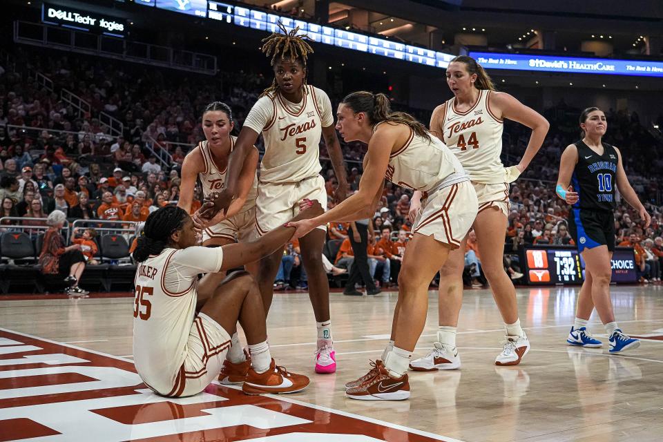 Texas Longhorns guard Madison Booker (35) is helped up by team mates during the basketball game against BYU at the Moody Center on Saturday, Mar. 2, 2024 in Austin.