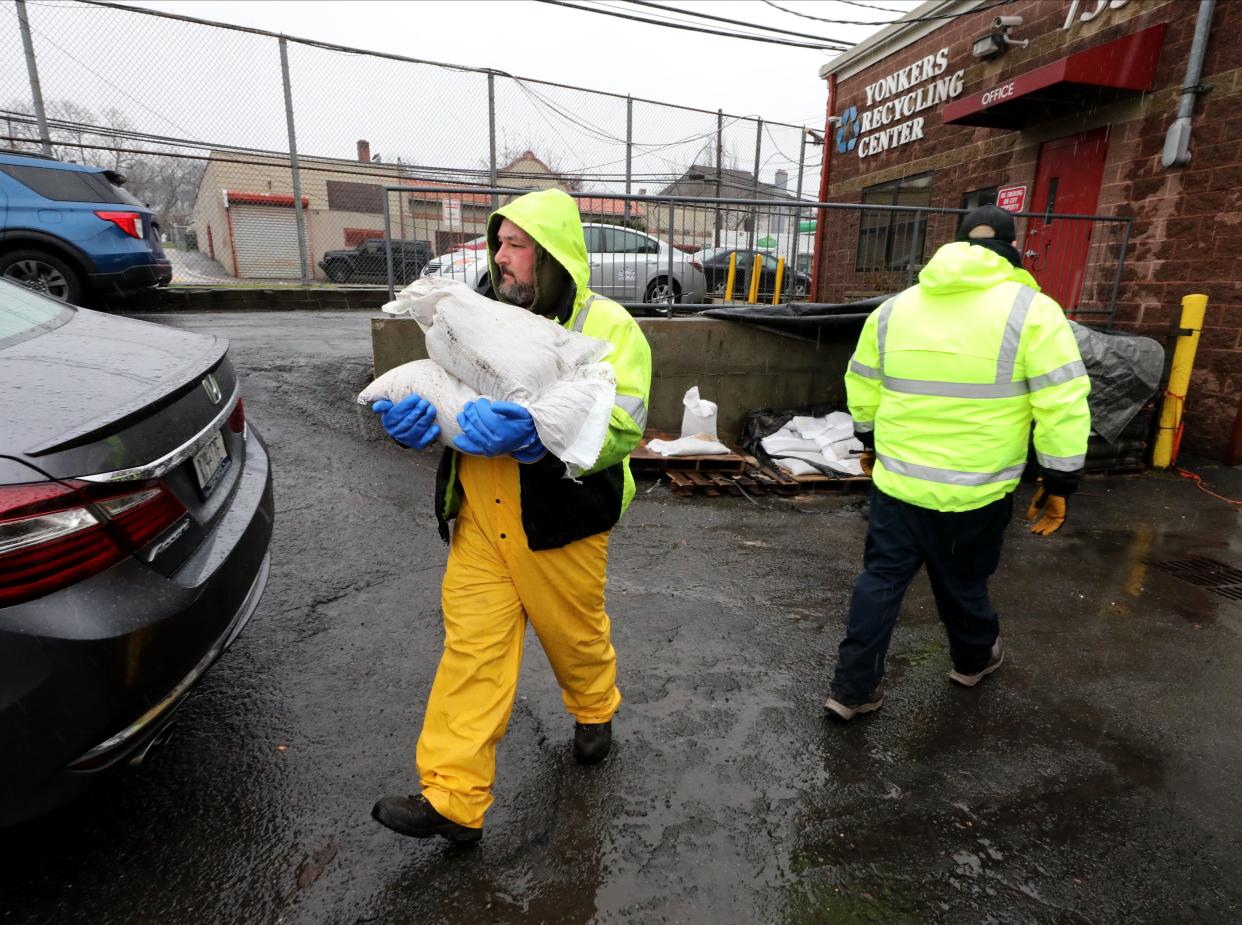 Yonkers Department of Public Works employees carry sandbags to waiting Yonkers residents, as they distribute them at the Yonkers Recycling Center on Saw Mill River Road, March 23, 2024.