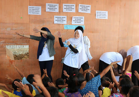 Workers of an aid group play with children in a temporary housing complex in Marawi, southern Philippines May 22, 2018. REUTERS/Neil Jerome Morales