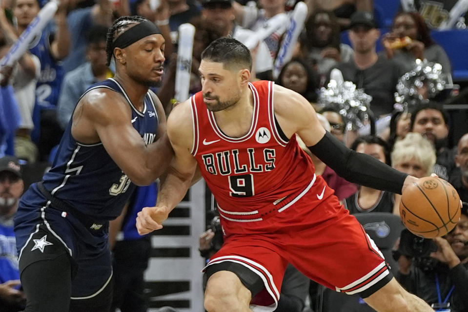 Chicago Bulls center Nikola Vucevic (9) makes a move to the basket against Orlando Magic center Wendell Carter Jr. during the first half of an NBA basketball game, Sunday, April 7, 2024, in Orlando, Fla. (AP Photo/John Raoux)