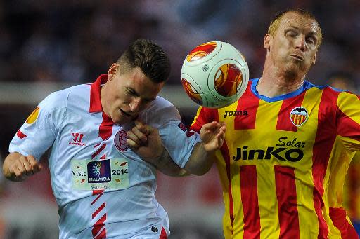 El francés Kevin Gameiro (I) del Sevilla, intenta cabecear ante la marca del francés Jeremy Mathieu del Valencia en el partido de ida de semifinales de la UEFA Europa League jugado el 24 de abril de 2014 en el estadio Ramón Sánchez Pizjuán de Sevilla (AFP | Jorge Guerrero)