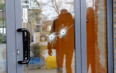 Bullet holes in a glass door in the town of Macerata. - Credit: AFP