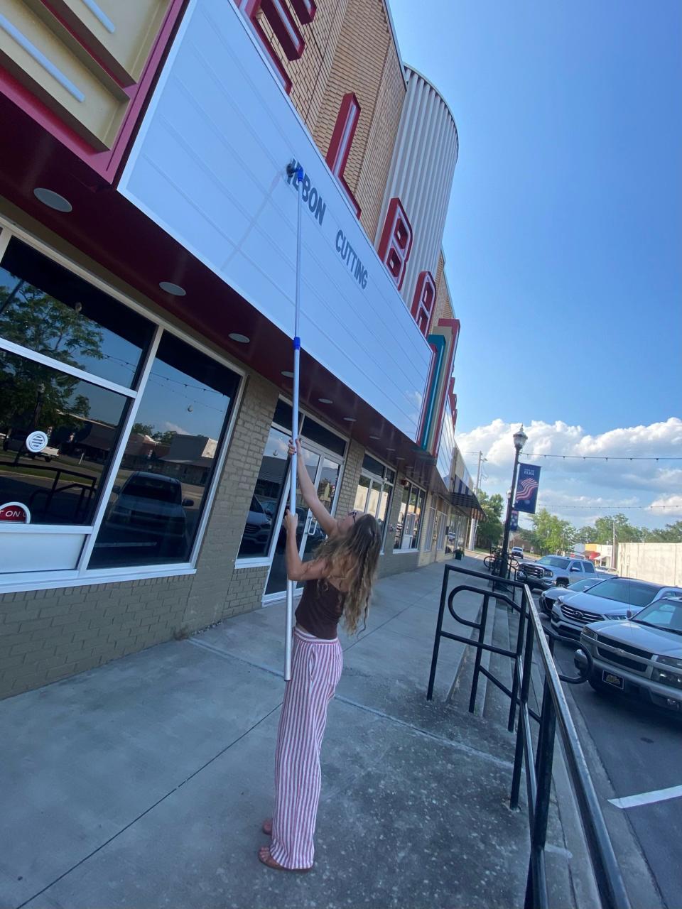 Living Democracy student Mikailie Caulder puts up a message on the marquee at The Elba Theatre.
