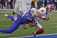 Oklahoma quarterback Dillon Gabriel (8) is tackled by Kansas linebacker Taiwan Berryhill Jr. (6) as he scores a touchdown during the first half of an NCAA college football game Saturday, Oct. 28, 2023, in Lawrence, Kan. (AP Photo/Charlie Riedel)