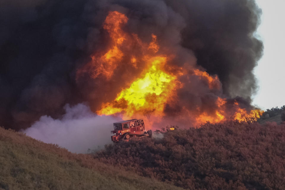 A bulldozer works to build a fire line on wildfire in Castaic, Calif. on Wednesday, Aug. 31, 2022. (AP Photo/Ringo H.W. Chiu)