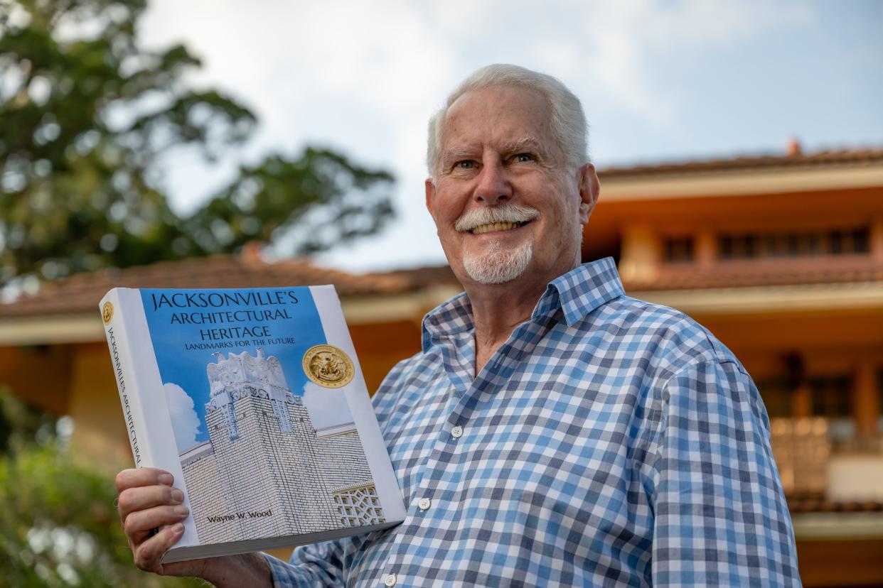 Wayne Wood displays his new book, "Jacksonville's Architectural Heritage: Landmarks for the Future," in front of his historic home.