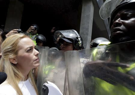 Lilian Tintori (L), wife of jailed Venezuelan opposition leader Leopoldo Lopez, faces a police officer as she attempts to deliver a letter demanding that the government set a date for this year's parliamentary elections, outside the National Electoral Council (CNE) offices in Caracas, June 16, 2015. REUTERS/Jorge Dan Lopez