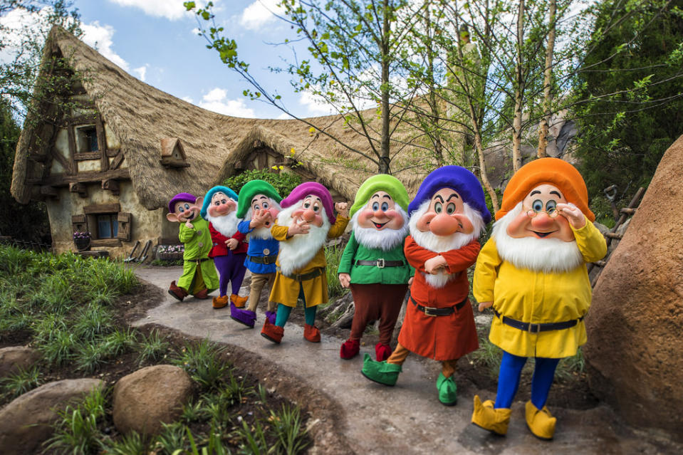 Snow White's seven dwarfs lined up just outside their family coaster attraction.