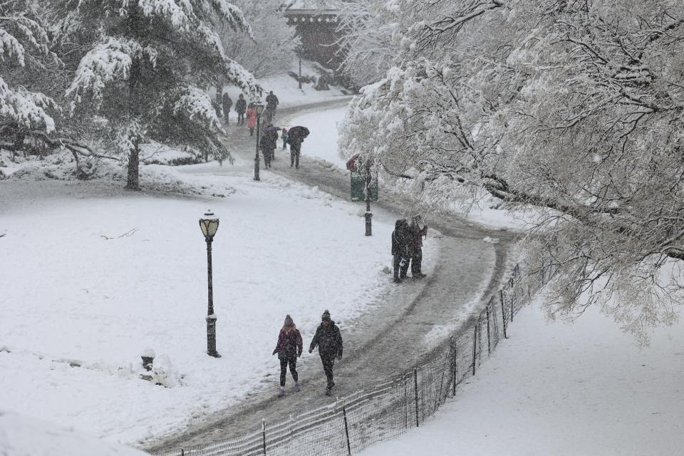People walk through the snow in Central Park in New York City on 13 February 13 2024 (AFP via Getty Images)