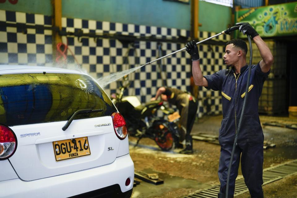 A worker washes a car at an ecological carwash in Bogota, Colombia, Friday, April 12, 2024. Water rationing in the capital began on Thursday due to the low level of water in reservoirs that give drinking water to the capital, a consequence of the El Niño weather phenomenon. (AP Photo/Fernando Vergara)