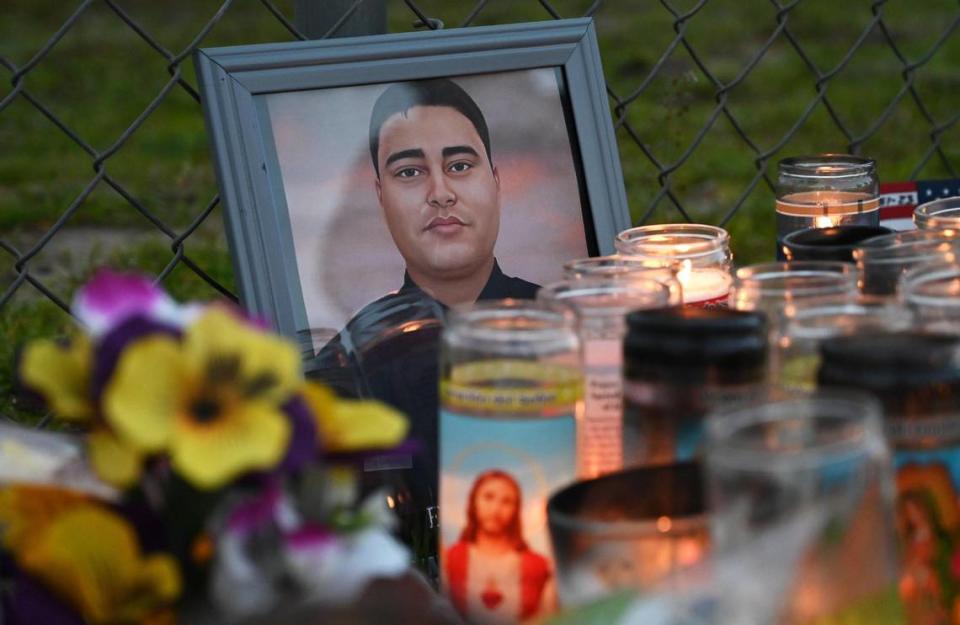 A photo of slain Selma officer Gonzalo Carrasco Jr. is seen at a curbside memorial along Pine Street Thursday evening, Feb 2, 2023 in Selma.