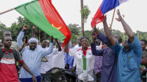 Demonstrators gather near Thomas Sankara memorial with Burkina Faso and Russian flags in support of what they believe to be another military coup in Ouagadougou Friday Sept. 30, 2022. Residents say gunfire rang out early in the morning and the state broadcaster has gone off the air, fueling fears that another coup is underway. The developments Friday come just after coup leader-turned-president Lt. Col. Paul Henri Sandaogo Damiba returned from a trip to the U.N. General Assembly. (AP Photo)