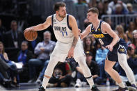 Dallas Mavericks guard Luka Doncic, left, looks to pass the ball as Denver Nuggets guard Christian Braun defends in the second half of an NBA basketball game Tuesday, Dec. 6, 2022, in Denver. (AP Photo/David Zalubowski)