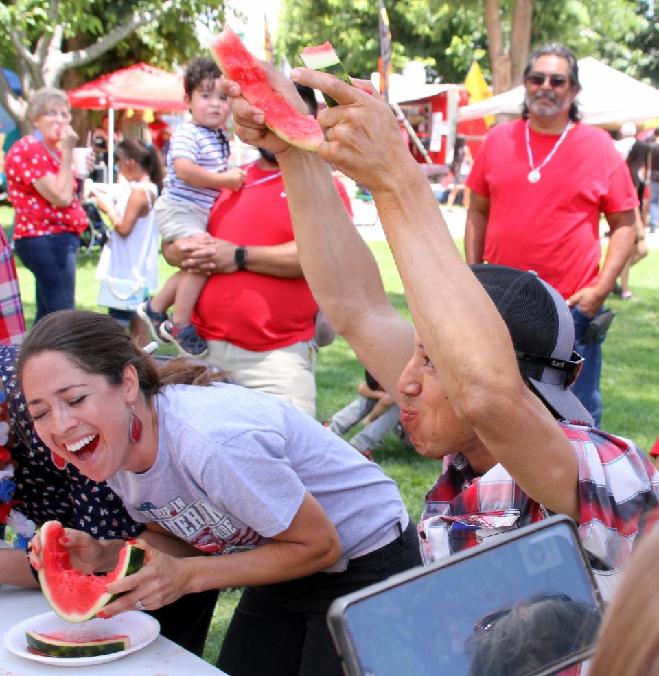 Diego Quintana raised his arms in victory while his wife Raquel (left) took notice during the Watermelon Eating Contest at Luna County Courthouse Park.
