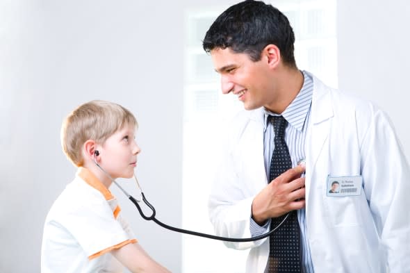 Boy listening to doctor's heartbeat with stethoscope