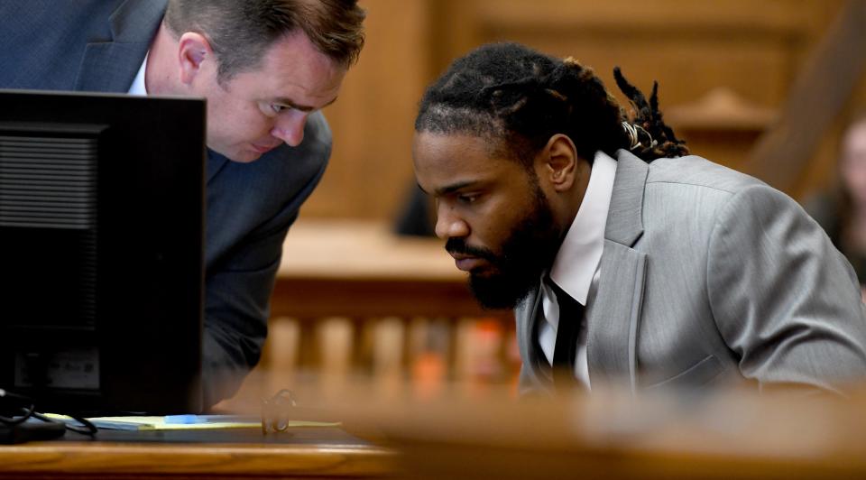 Errol G. Frank III, right, speaks Tuesday with defense attorney Aaron Kovalchik while on trial in Stark County Common Pleas Court. He faces felony charges of murder, felonious assault and tampering with evidence with gun specifications in the death of Melvin Stevenson in March.