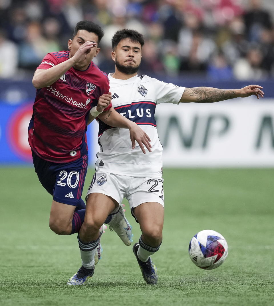 FC Dallas' Alan Velasco, left, and Vancouver Whitecaps' Ryan Raposo collide during the first half of an MLS soccer match in Vancouver, British Columbia, Saturday, March 11, 2023. (Darryl Dyck/The Canadian Press via AP)